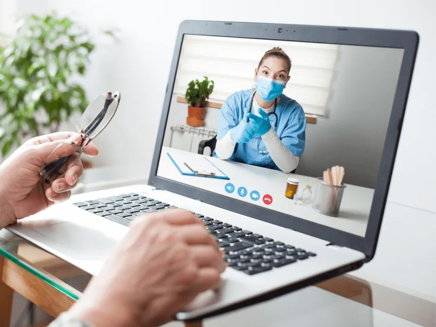 An adult patient talking with a healthcare provider during a virtual appointment from home
